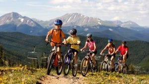 A family with young children leading the way experiences mountain biking in Colorado.